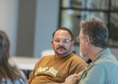 Two participants turn toward each other during a Lived Experience Committee discussion.