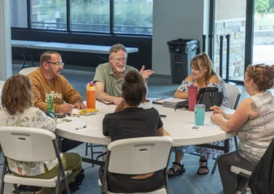 Lived Experience Committee participants gather around a table with notes and drinks.