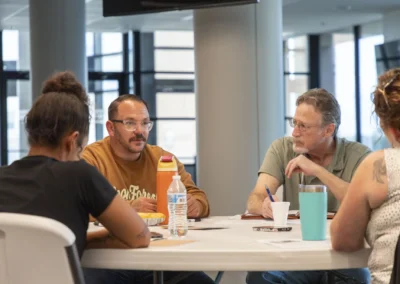 Participants listen and exchange ideas around the Lived Experience Committee meeting table.