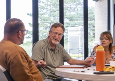 A participant gestures while speaking with others at the Lived Experience Committee meeting.