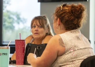 Participants talk across the table during the Lived Experience Committee meeting.