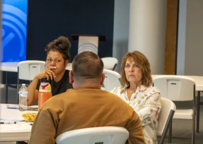 Participants listen to one another across the Lived Experience Committee meeting table.